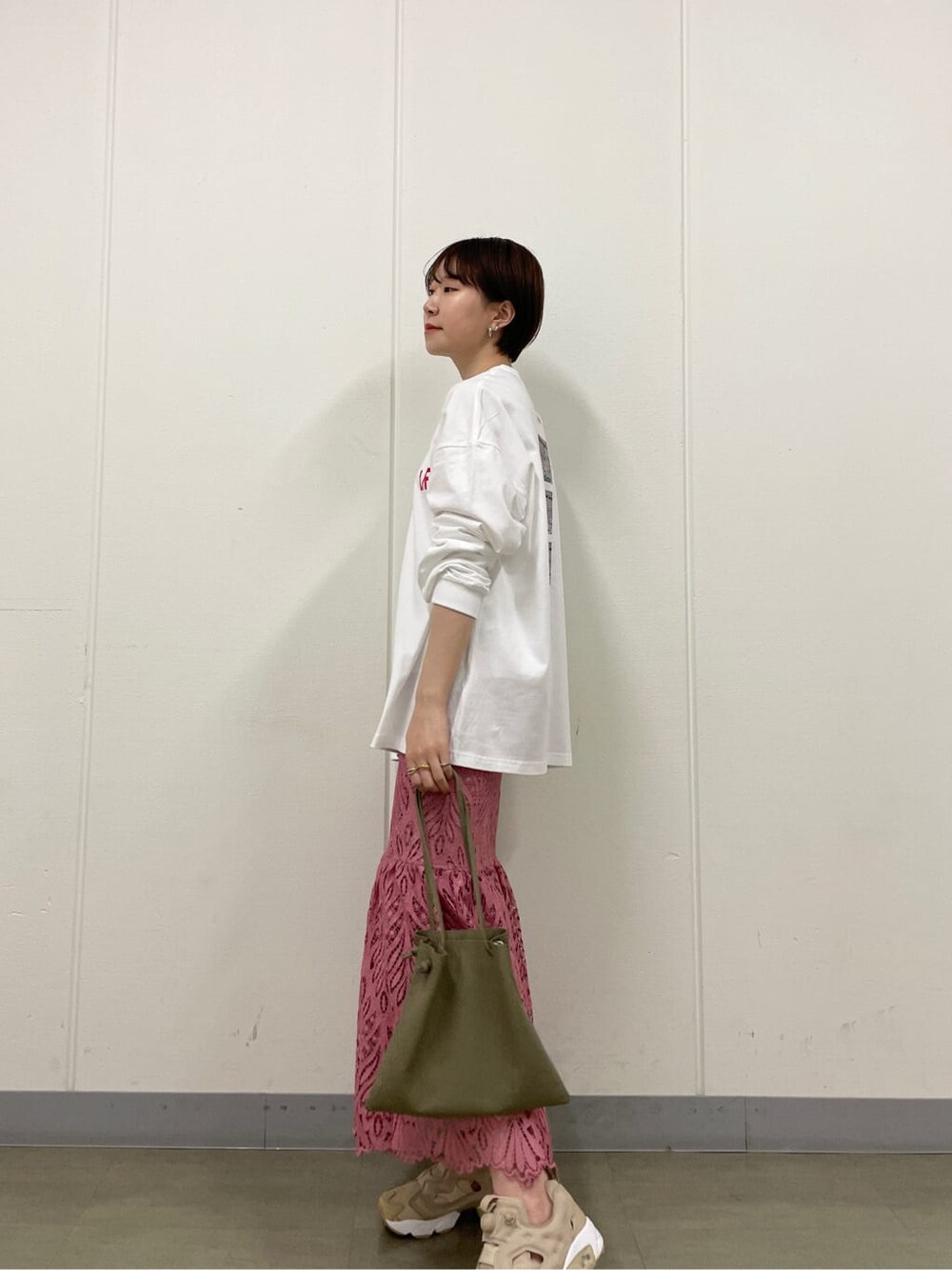 ピンク系のスカート、ホワイト系のTシャツ/カットソー、ベージュ系のスニーカーを着用したレディースの春コーディネートの3枚目の写真