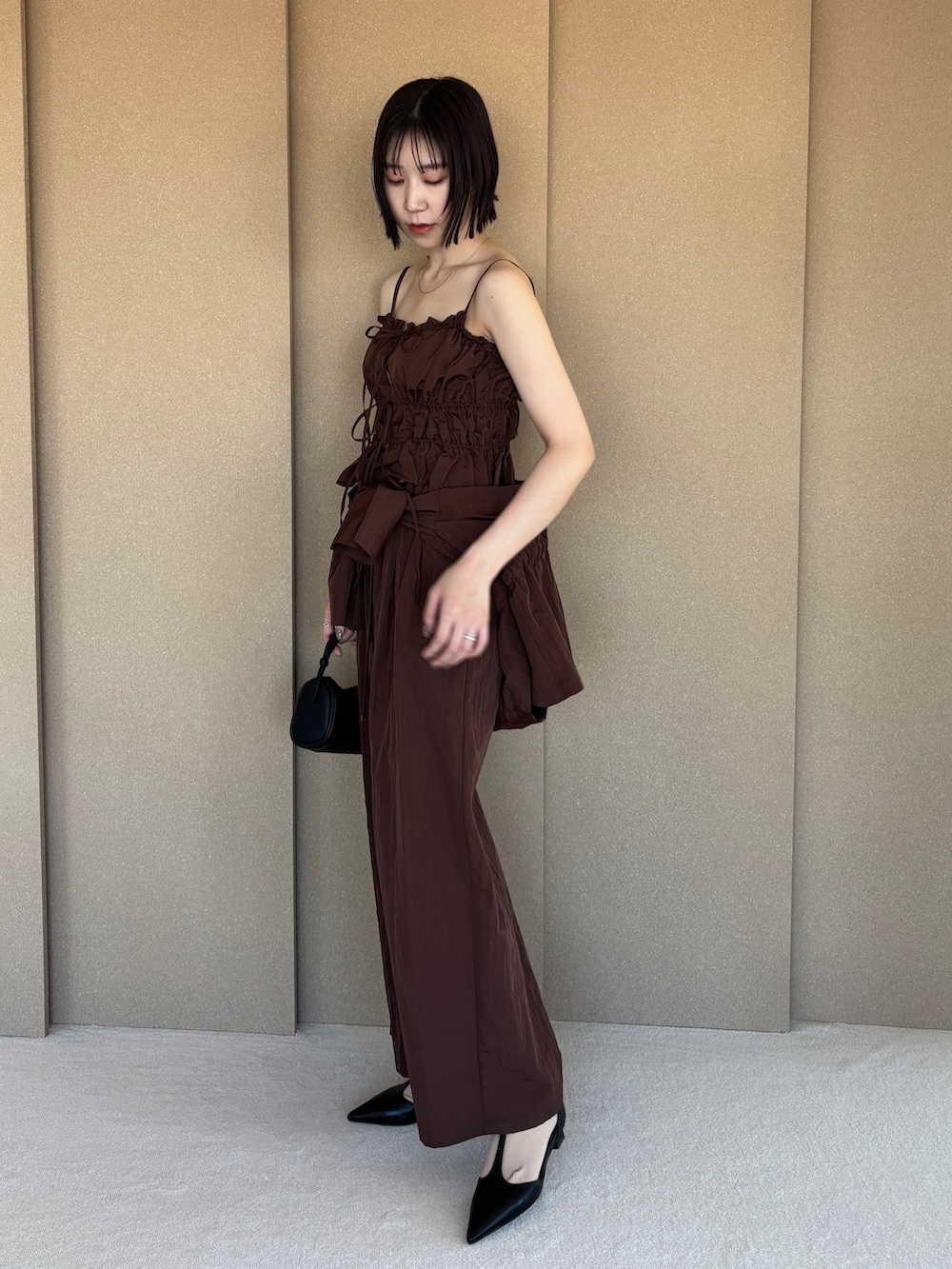 ブラウン系のその他パンツ、ブラック系のパンプス、ブラウン系のキャミソールを着用したレディースの春コーディネートの3枚目の写真
