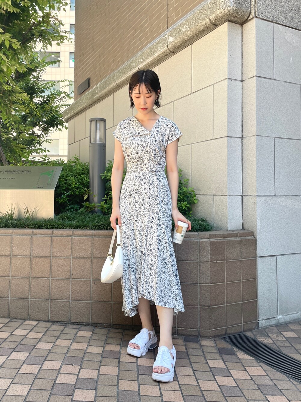 ホワイト系のワンピース、ホワイト系のハンドバッグを着用したレディースの夏コーディネートの3枚目の写真