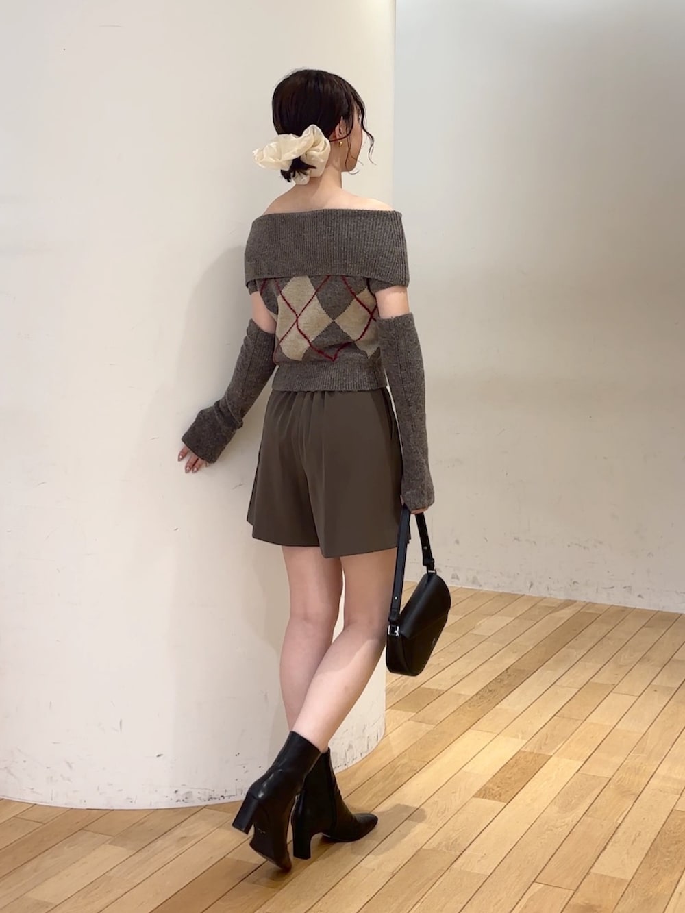 ブラウン系のその他パンツ、ブラウン系のニット/セーター、ブラック系のハンドバッグを着用したレディースの秋コーディネートの3枚目の写真