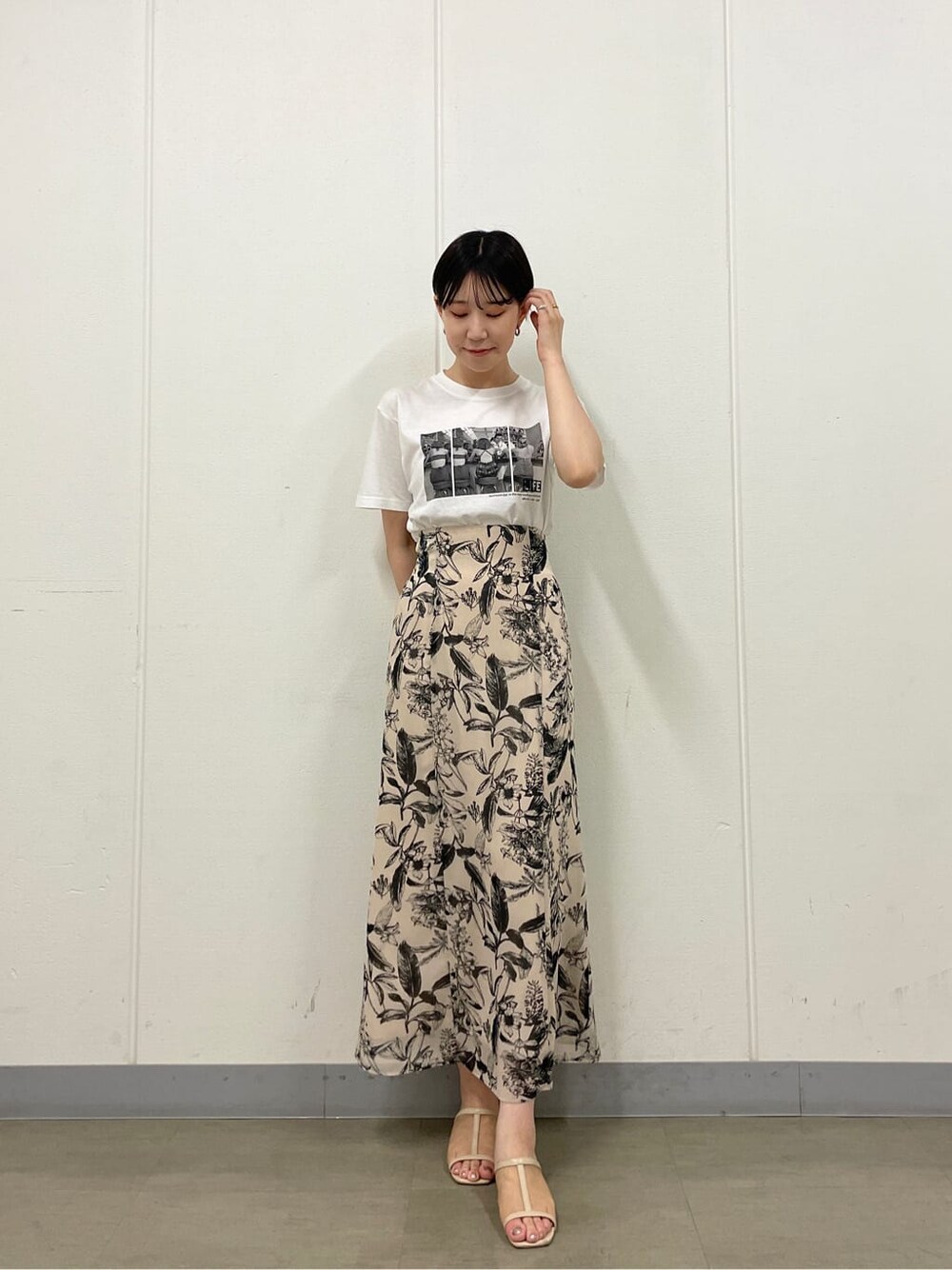 ベージュ系のスニーカー、ホワイト系のTシャツ/カットソー、ベージュ系のスカートを着用したレディースの夏コーディネートの3枚目の写真