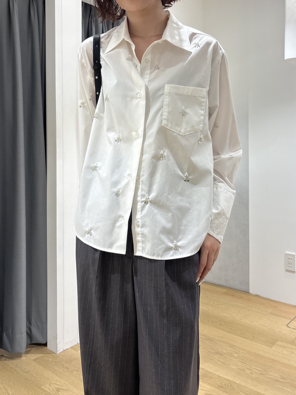 グレー系のその他パンツ、ホワイト系のシャツ/ブラウス、ブラック系のハンドバッグを着用したレディースの秋コーディネートの5枚目の写真