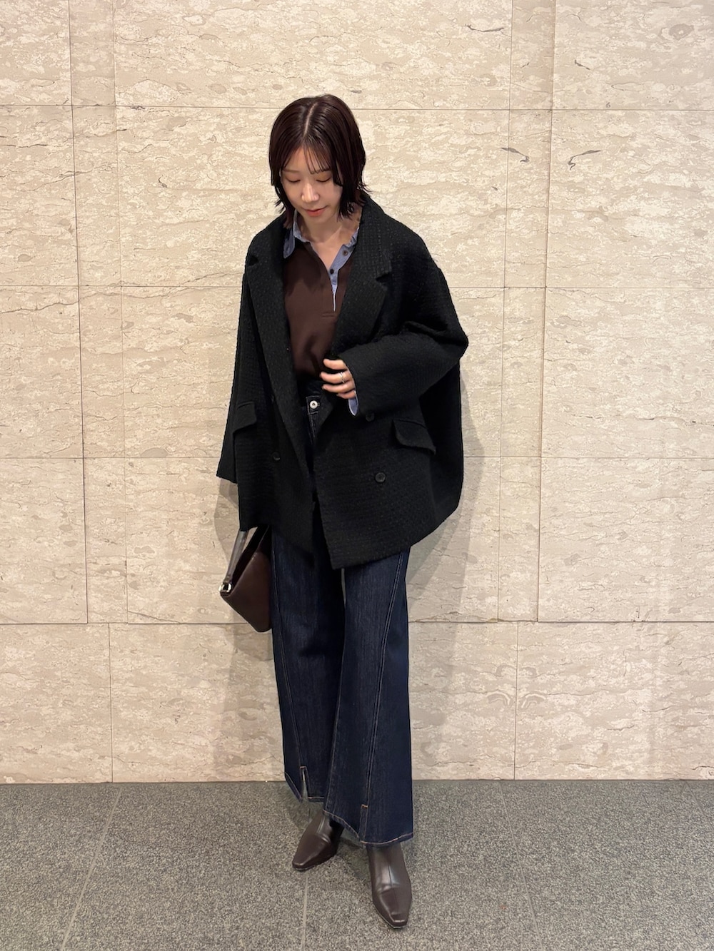 ブラウン系のニット/セーター、ブラック系のその他アウター、ブラウン系のブーツを着用したレディースの冬コーディネートの2枚目の写真