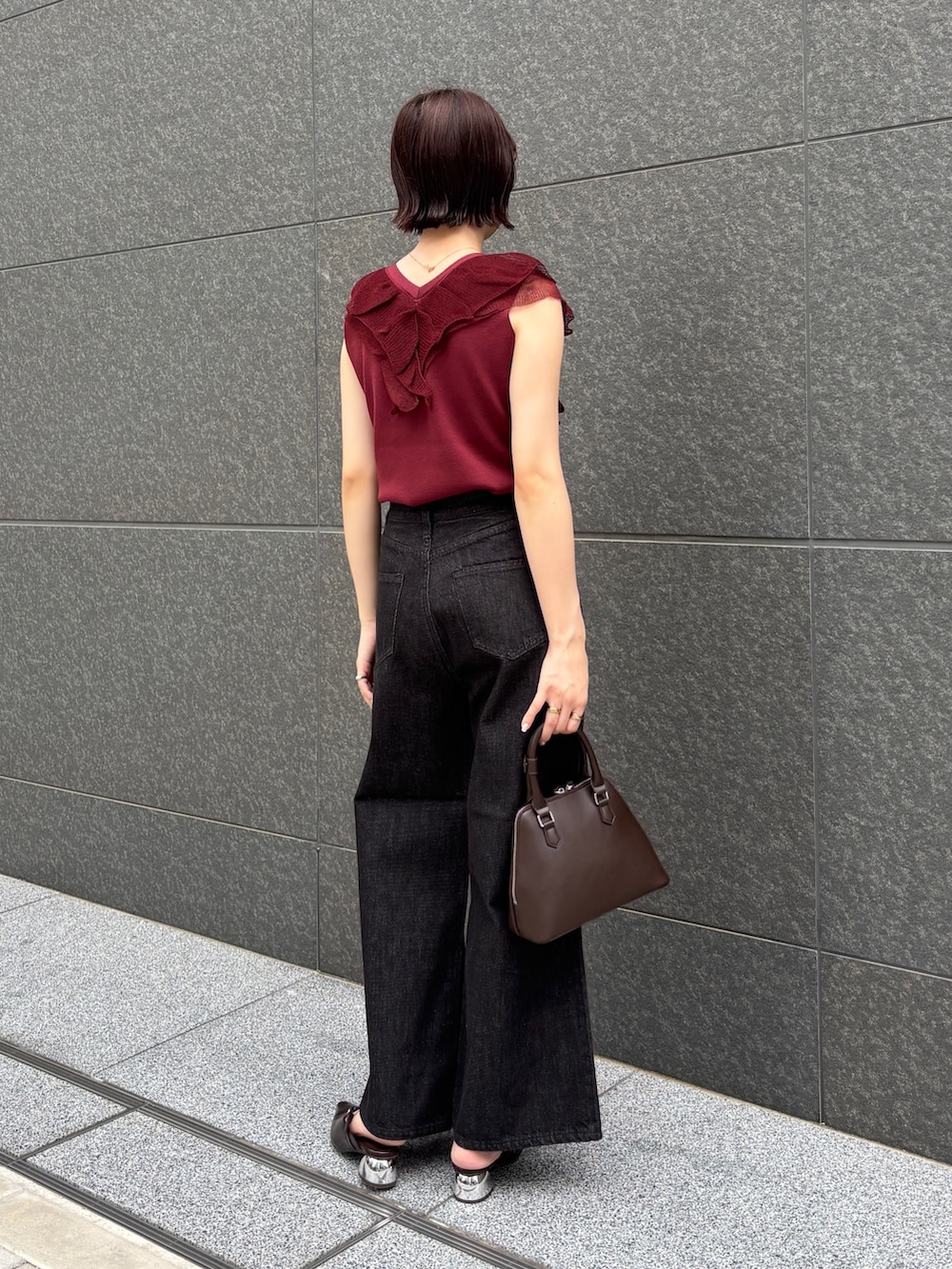 ブラウン系のボストンバッグ、ブラック系のデニムパンツ、ブラウン系のパンプスを着用したレディースの夏コーディネートの3枚目の写真