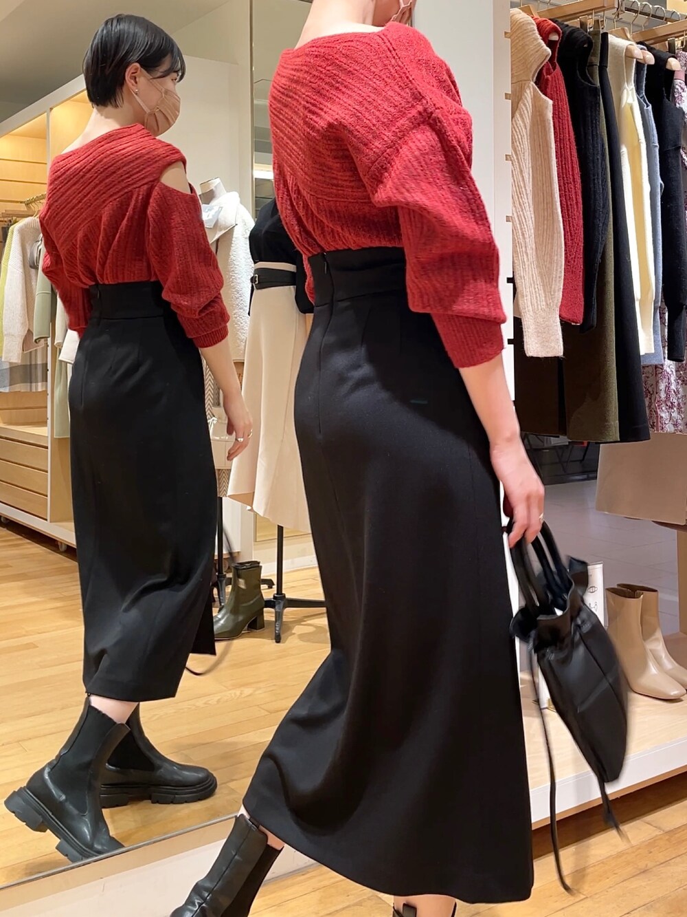 ブラック系のスカート、ブラック系のニット/セーター、ブラック系のハンドバッグを着用したレディースの冬コーディネートの4枚目の写真