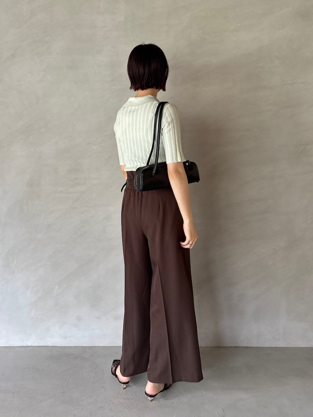 ブラウン系のその他パンツ、グリーン系のニット/セーター、ブラック系のサンダルを着用したレディースの夏コーディネートの3枚目の写真