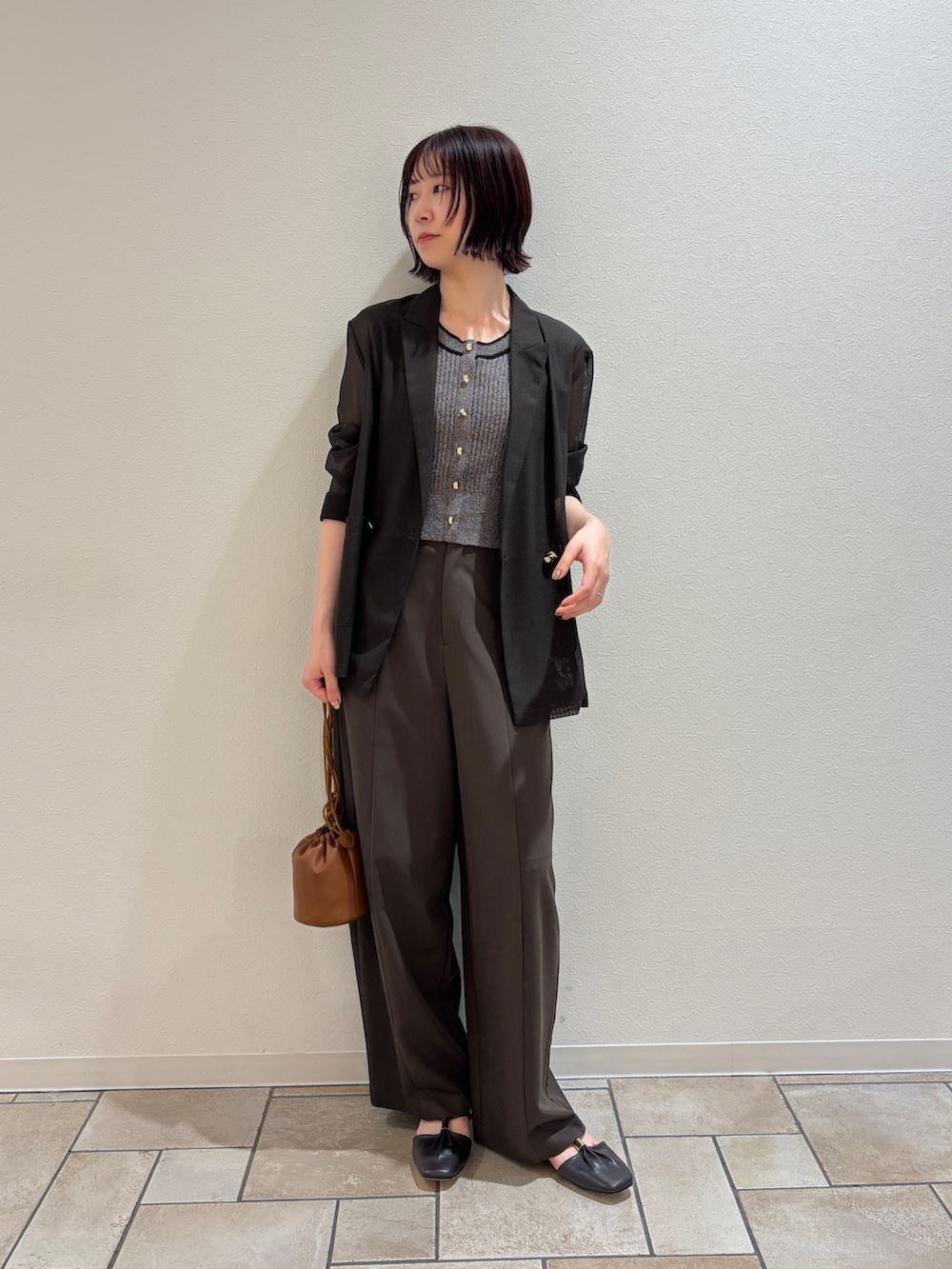 ブラウン系のその他パンツ、グレー系のニット/セーター、イエロー系のハンドバッグを着用したレディースの夏コーディネートの5枚目の写真