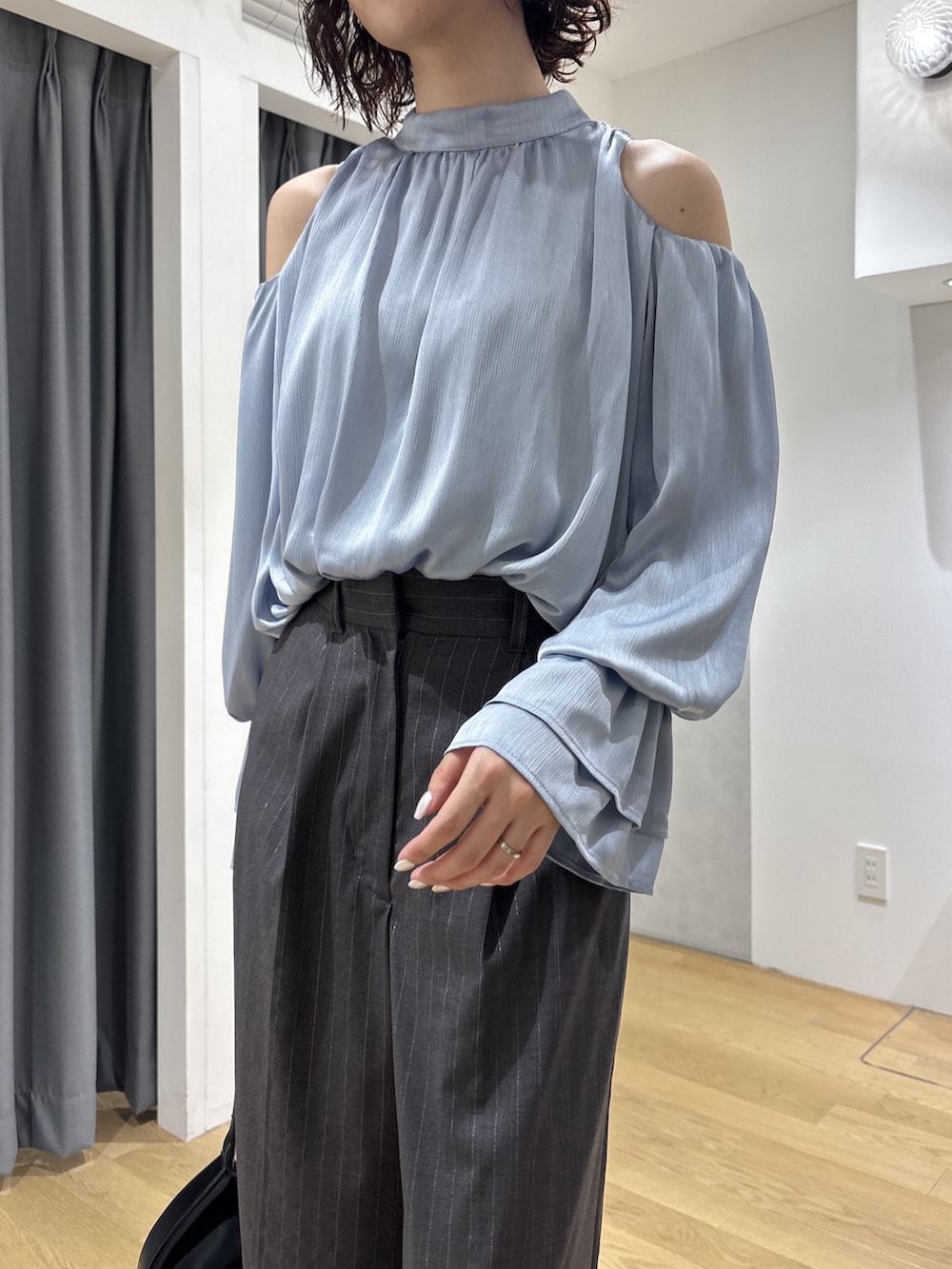 ブルー系のシャツ/ブラウス、グレー系のその他パンツ、ブラック系のハンドバッグを着用したレディースの秋コーディネートの5枚目の写真