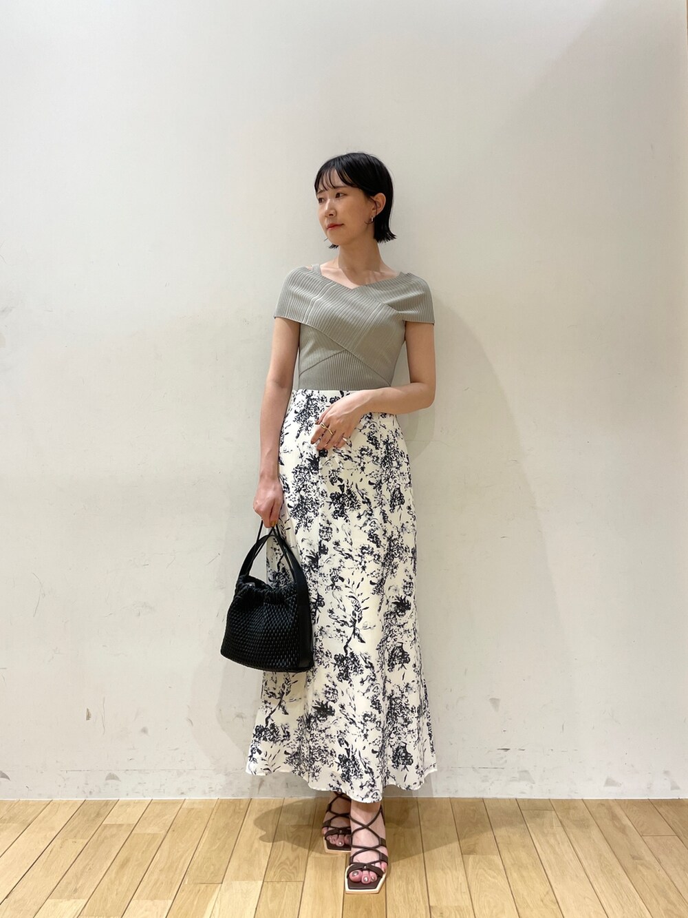 グリーン系のニット/セーター、ブルー系のスカート、ブラウン系のサンダルを着用したレディースの夏コーディネートの3枚目の写真