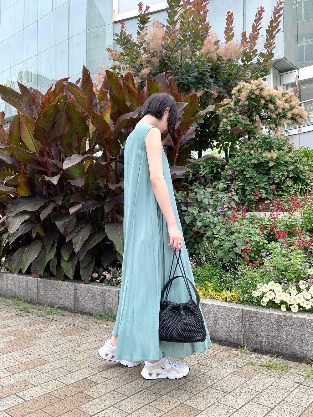 グリーン系のワンピース、ブラック系のハンドバッグを着用したレディースの夏コーディネートの3枚目の写真