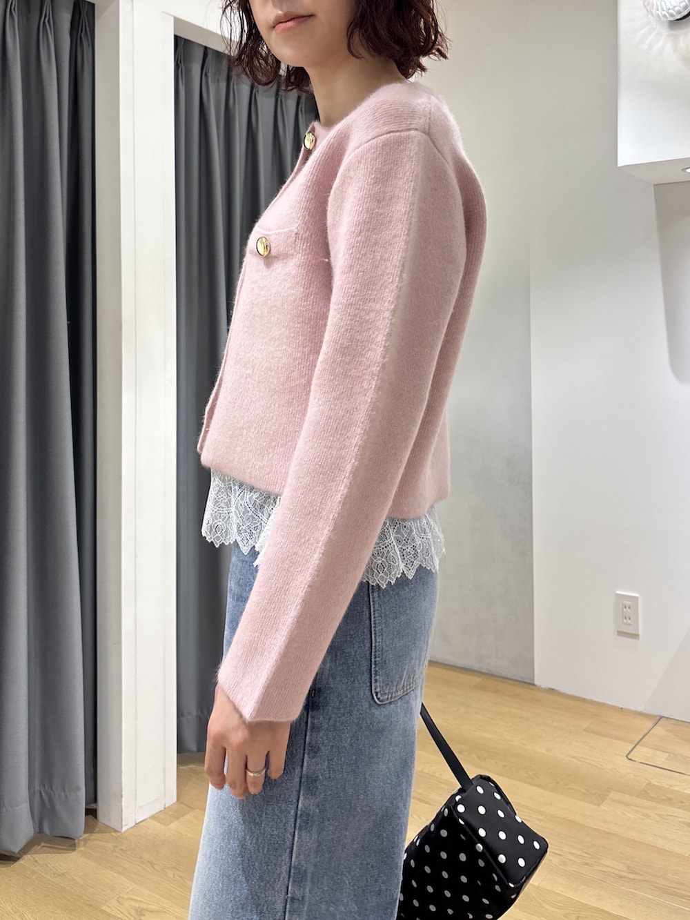 ブルー系のデニムパンツ、ピンク系のキャミソール、ピンク系のノーカラージャケットを着用したレディースの秋コーディネートの7枚目の写真