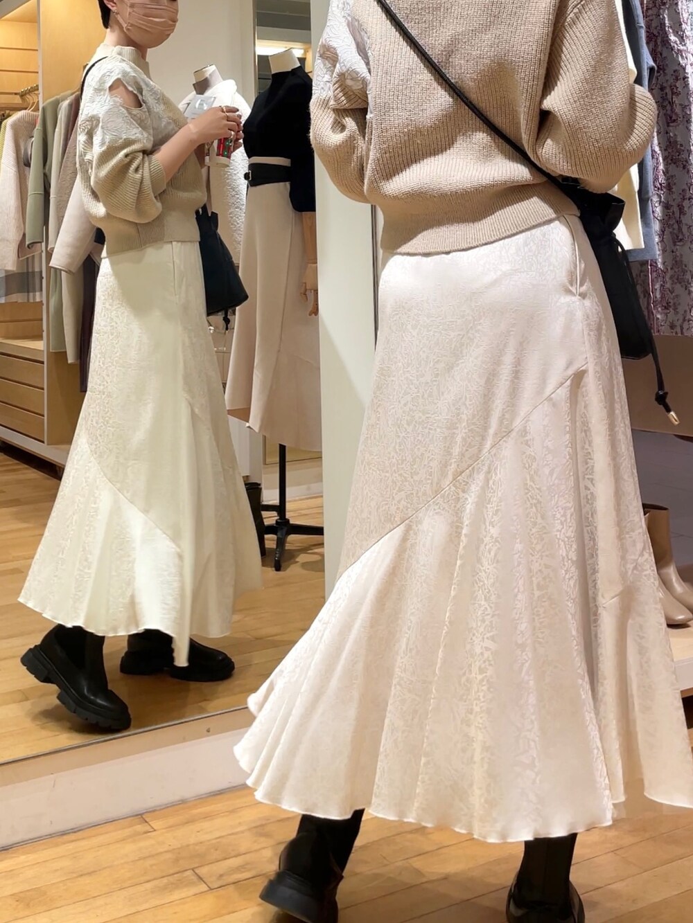 ベージュ系のニット/セーター、ホワイト系のスカート、ブラック系のハンドバッグを着用したレディースの冬コーディネートの4枚目の写真