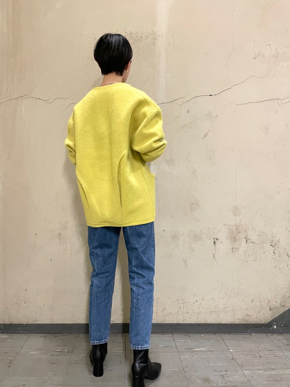 ブラック系のニット/セーター、イエロー系のカーディガン/ボレロ、ブルー系のデニムパンツを着用したレディースの秋コーディネートの3枚目の写真