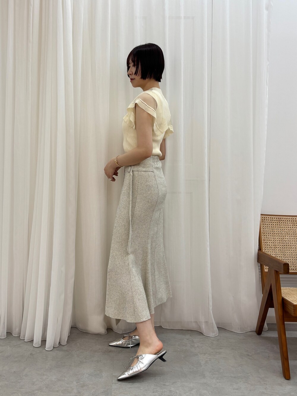 シルバー系のサンダル、ホワイト系のスカート、ホワイト系のニット/セーターを着用したレディースの春コーディネートの3枚目の写真