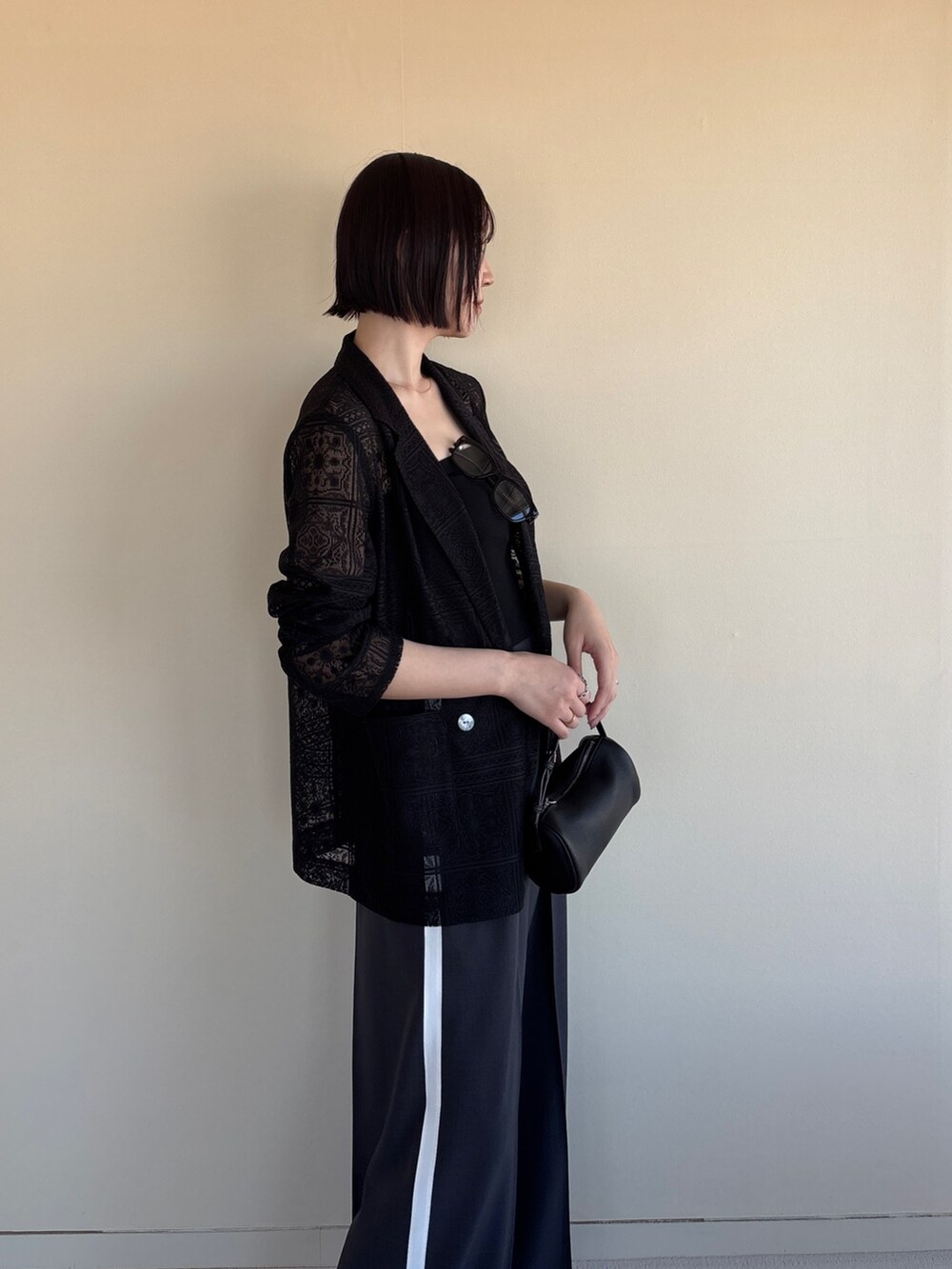 グレー系のその他パンツ、ブラック系のテーラードジャケット、ブラック系のチューブトップを着用したレディースの春コーディネートの4枚目の写真