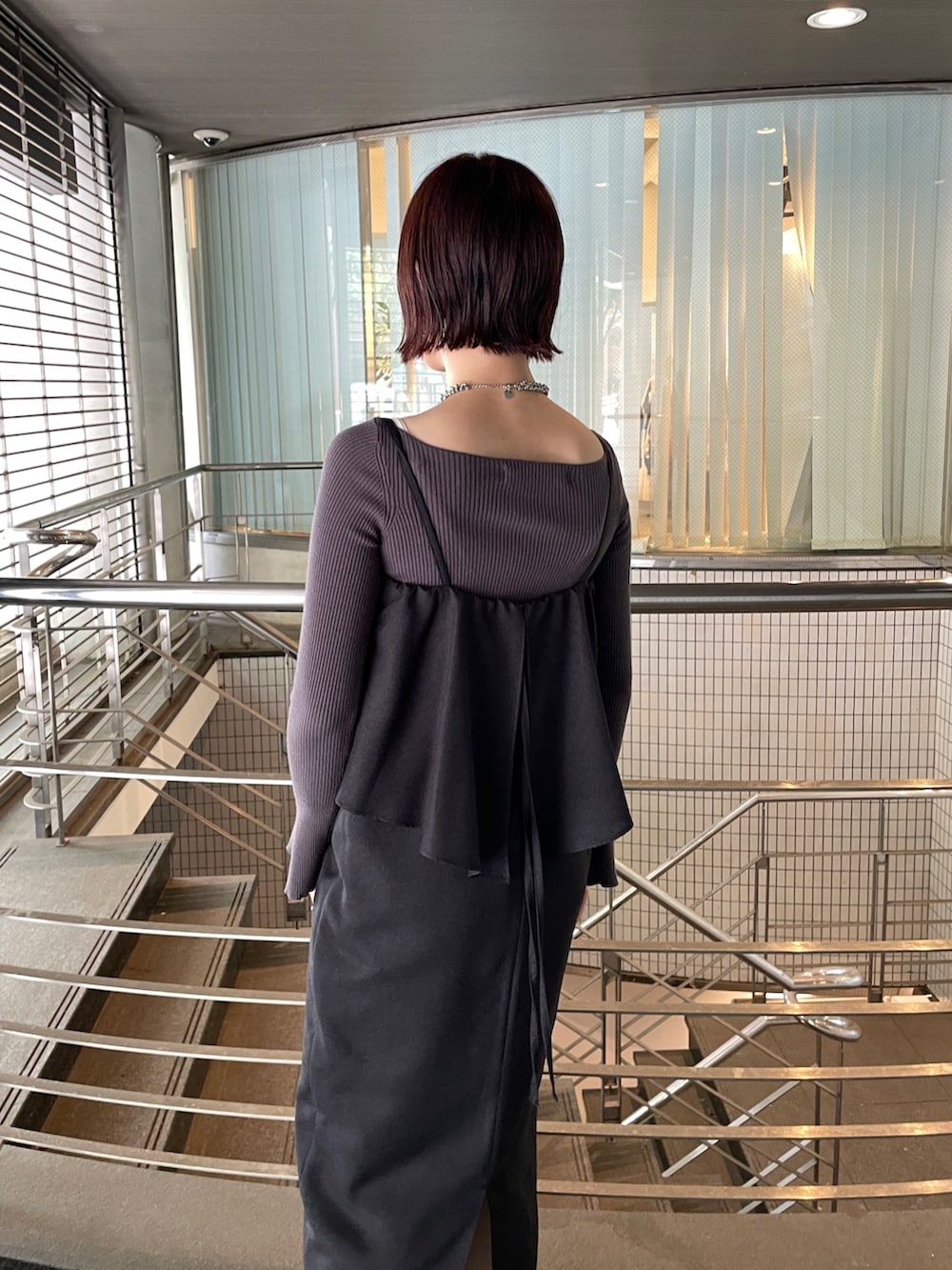 グレー系のニット/セーター、シルバー系のブーツ、ブラック系のワンピースを着用したレディースの秋コーディネートの7枚目の写真