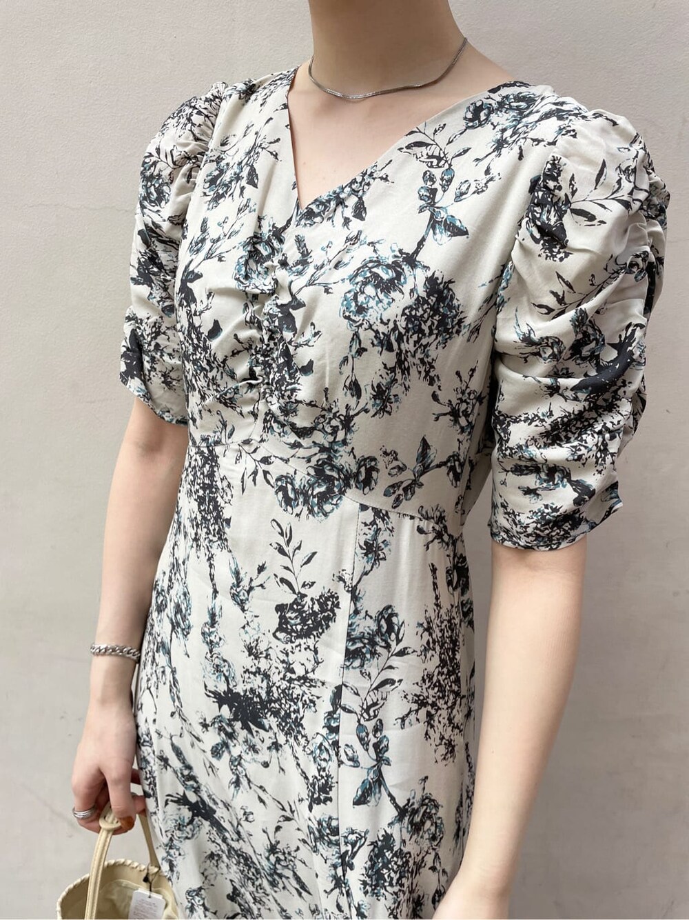 グレー系のワンピース、ブラック系のサンダル、ホワイト系のショルダーバッグを着用したレディースの春コーディネートの5枚目の写真