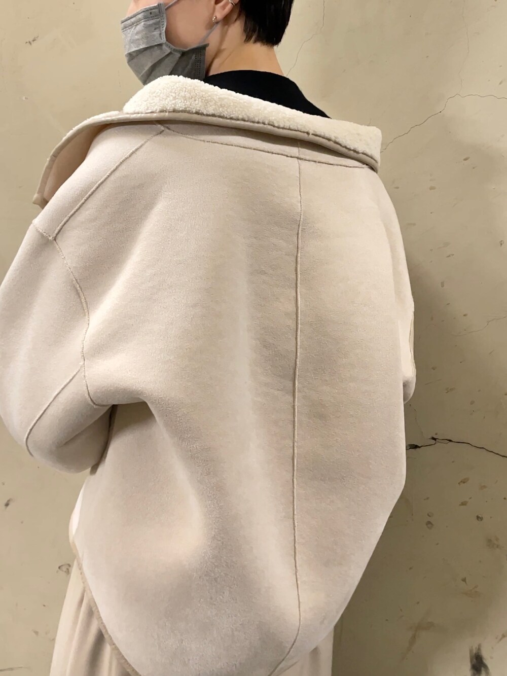 ホワイト系のブルゾン、ブラック系のブーツ、ベージュ系のスカートを着用したレディースの秋コーディネートの8枚目の写真