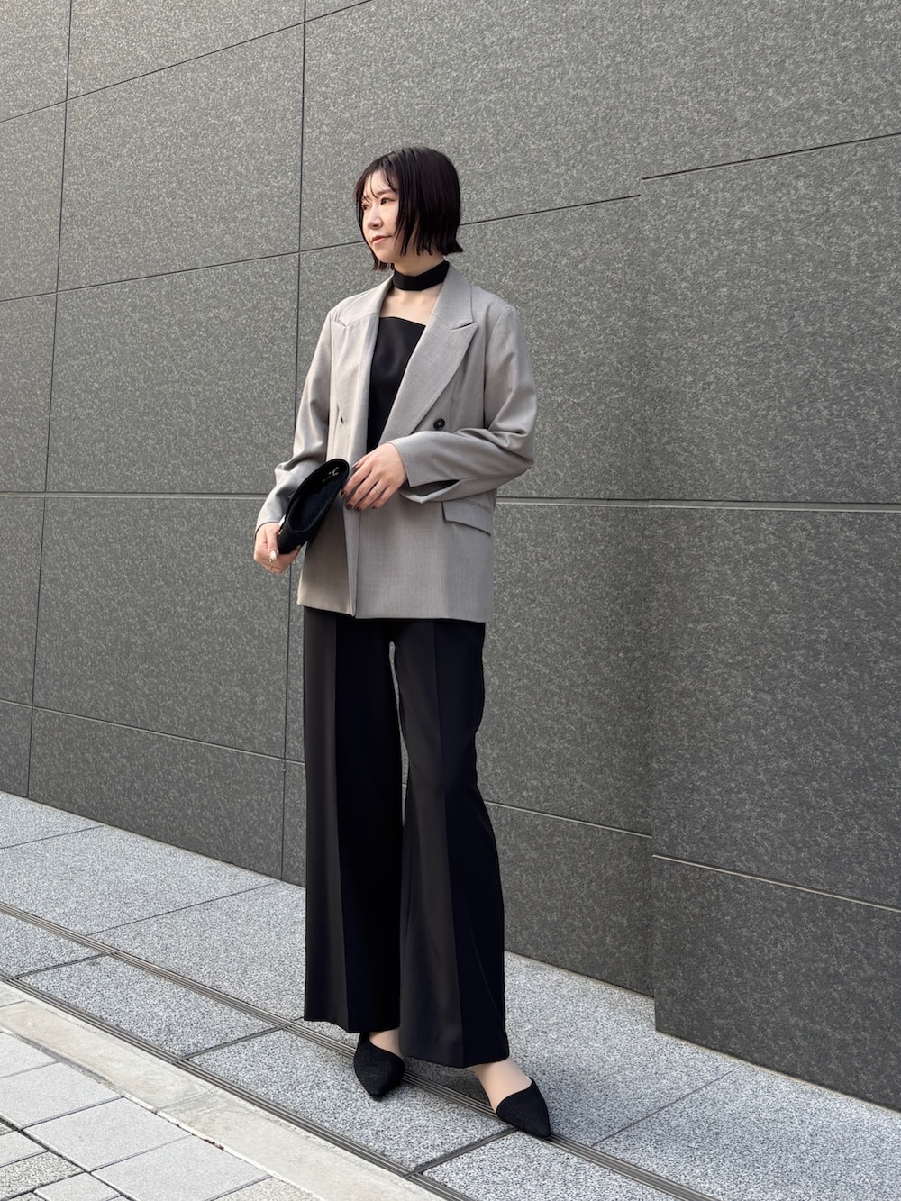 ブラック系のドレス、ブラック系のパンプス、ブラック系のハンドバッグを着用したレディースの冬コーディネートの5枚目の写真