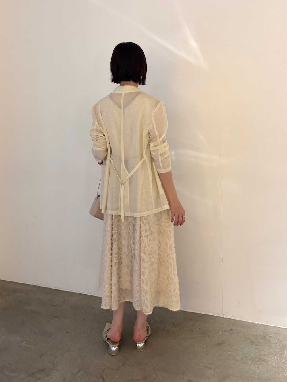 ホワイト系のワンピース、グリーン系のパンプスを着用したレディースの春コーディネートの5枚目の写真