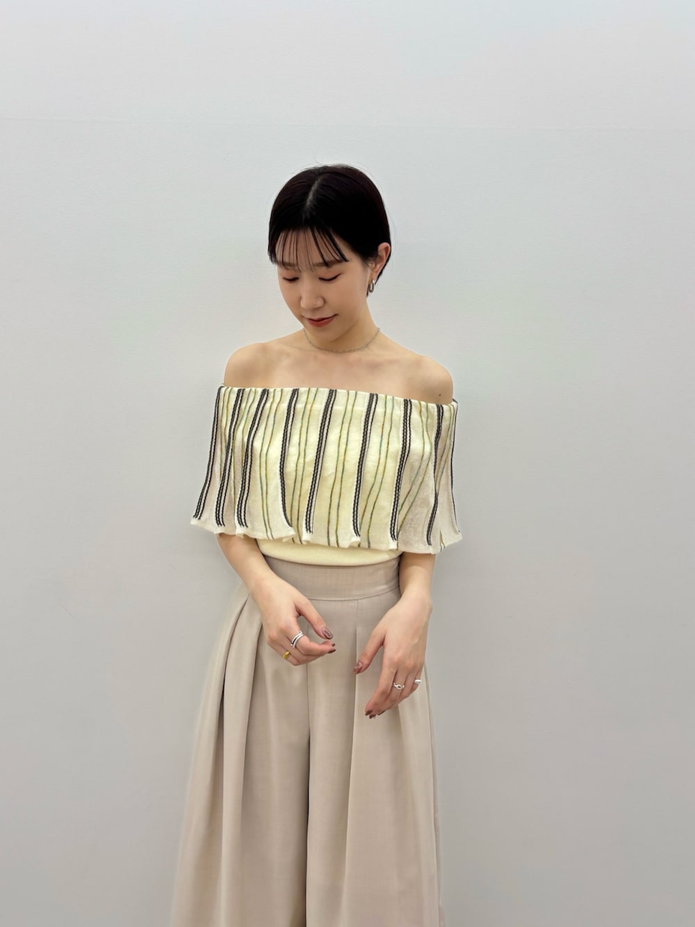 ホワイト系のニット/セーター、ベージュ系のその他パンツ、ホワイト系のサンダルを着用したレディースの春コーディネートの5枚目の写真