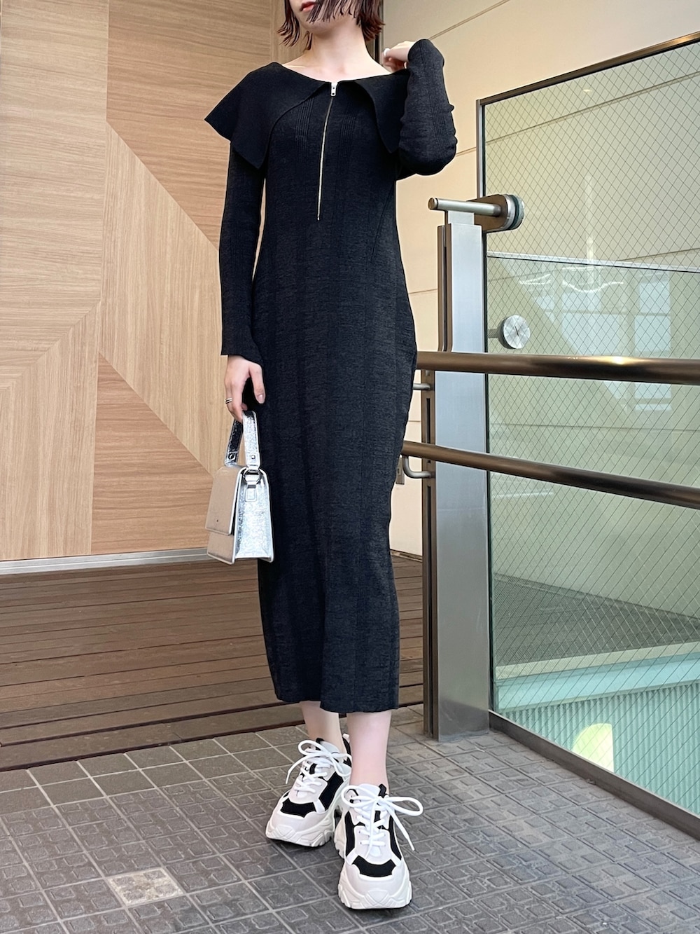 ブラック系のワンピース、ブラック系のスニーカー、シルバー系のショルダーバッグを着用したレディースの春コーディネートの5枚目の写真