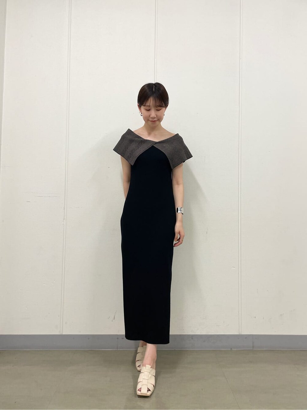 ホワイト系のサンダル、ブラック系のワンピース、シルバー系のバングル/リストバンドを着用したレディースの夏コーディネートの3枚目の写真