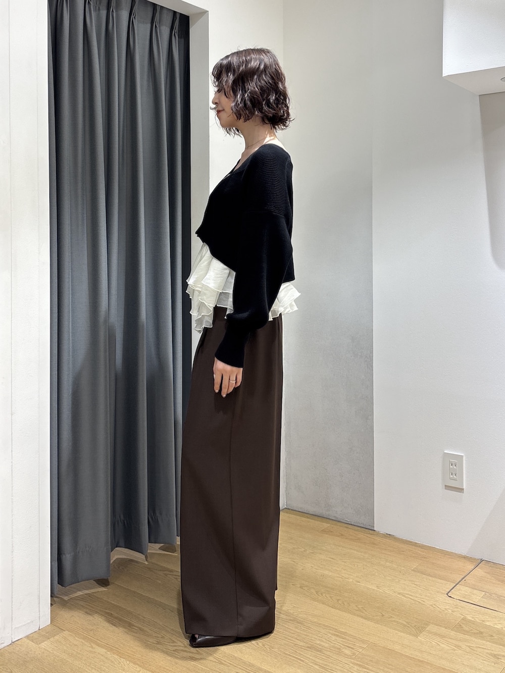 ブラウン系のその他パンツ、ブラック系のカーディガン/ボレロ、レッド系のハンドバッグを着用したレディースの秋コーディネートの3枚目の写真