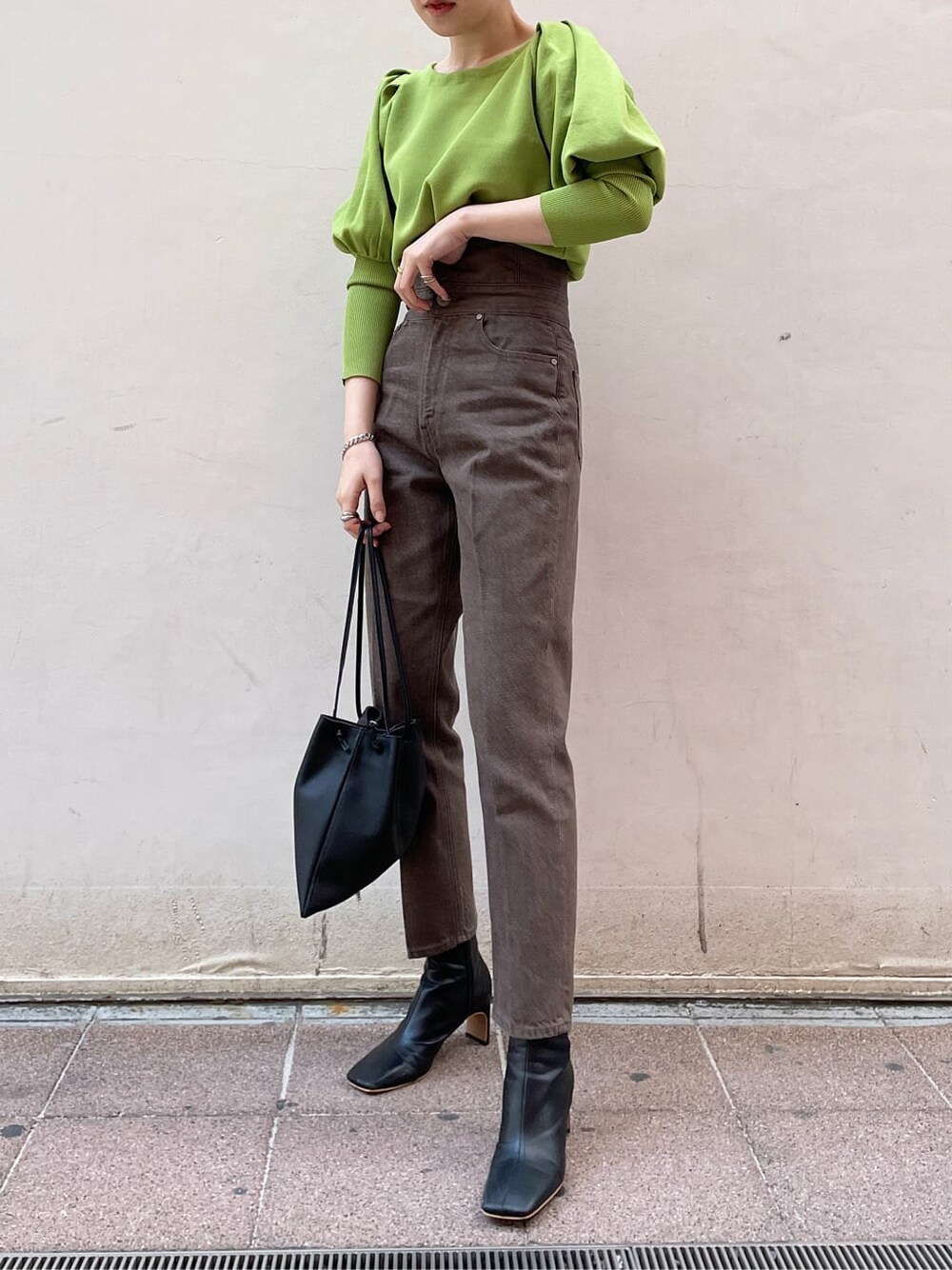 ブラック系のその他シューズ、ブラック系のハンドバッグ、グリーン系のニット/セーターを着用したレディースの冬コーディネートの3枚目の写真