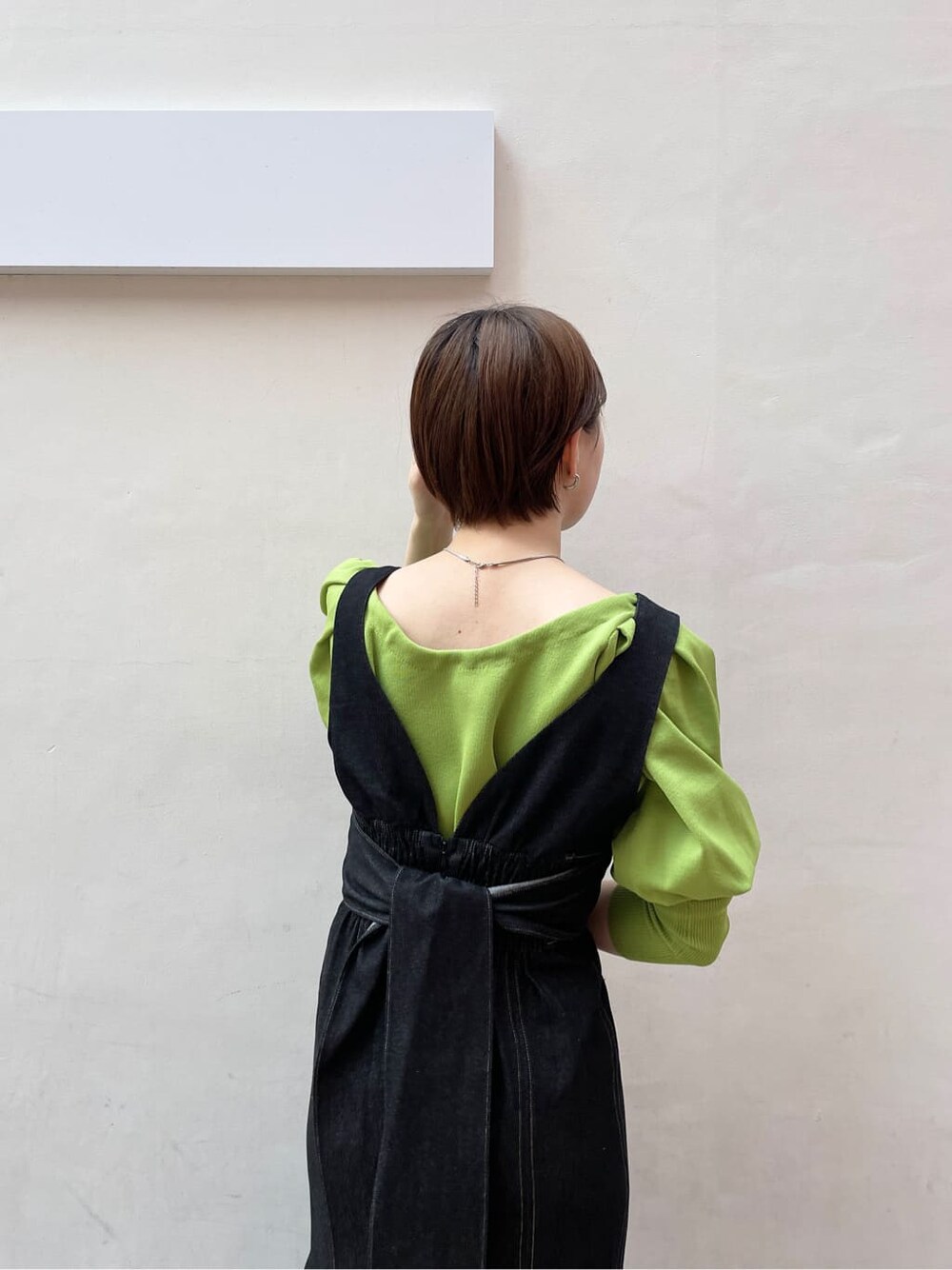 ブラック系のワンピース、グリーン系のニット/セーター、ブラック系のサンダルを着用したレディースの春コーディネートの9枚目の写真