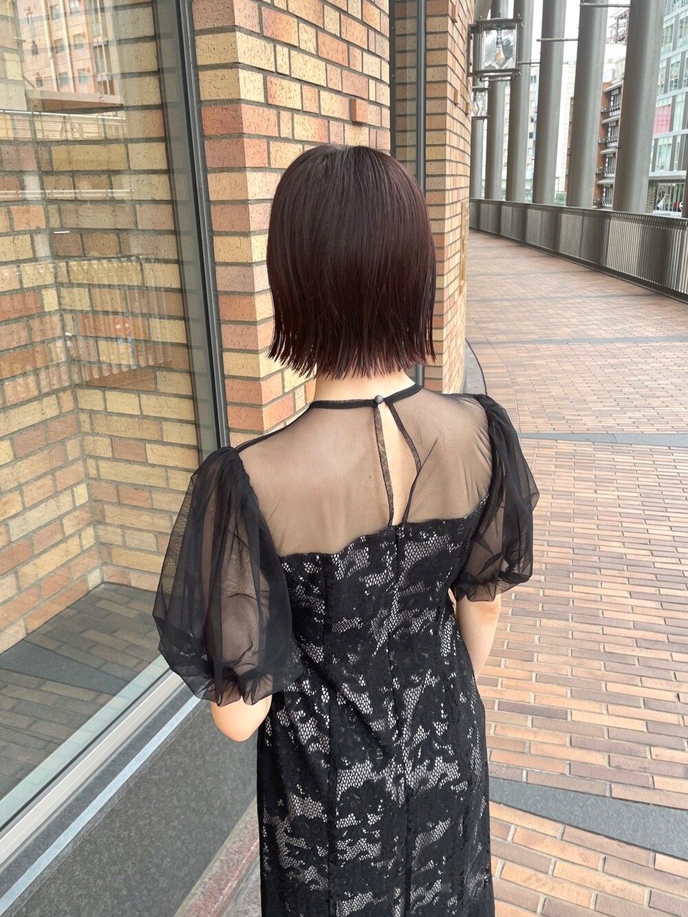 ブラック系のドレス、シルバー系のハンドバッグ、シルバー系のパンプスを着用したレディースの秋コーディネートの6枚目の写真