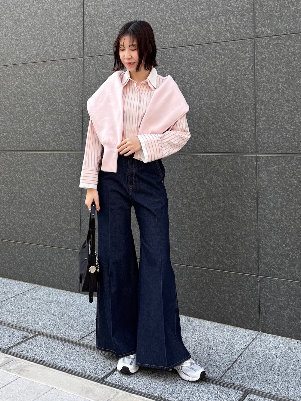 ピンク系のシャツ/ブラウス、ブルー系のデニムパンツ、ブラック系のハンドバッグを着用したレディースの春コーディネートの2枚目の写真