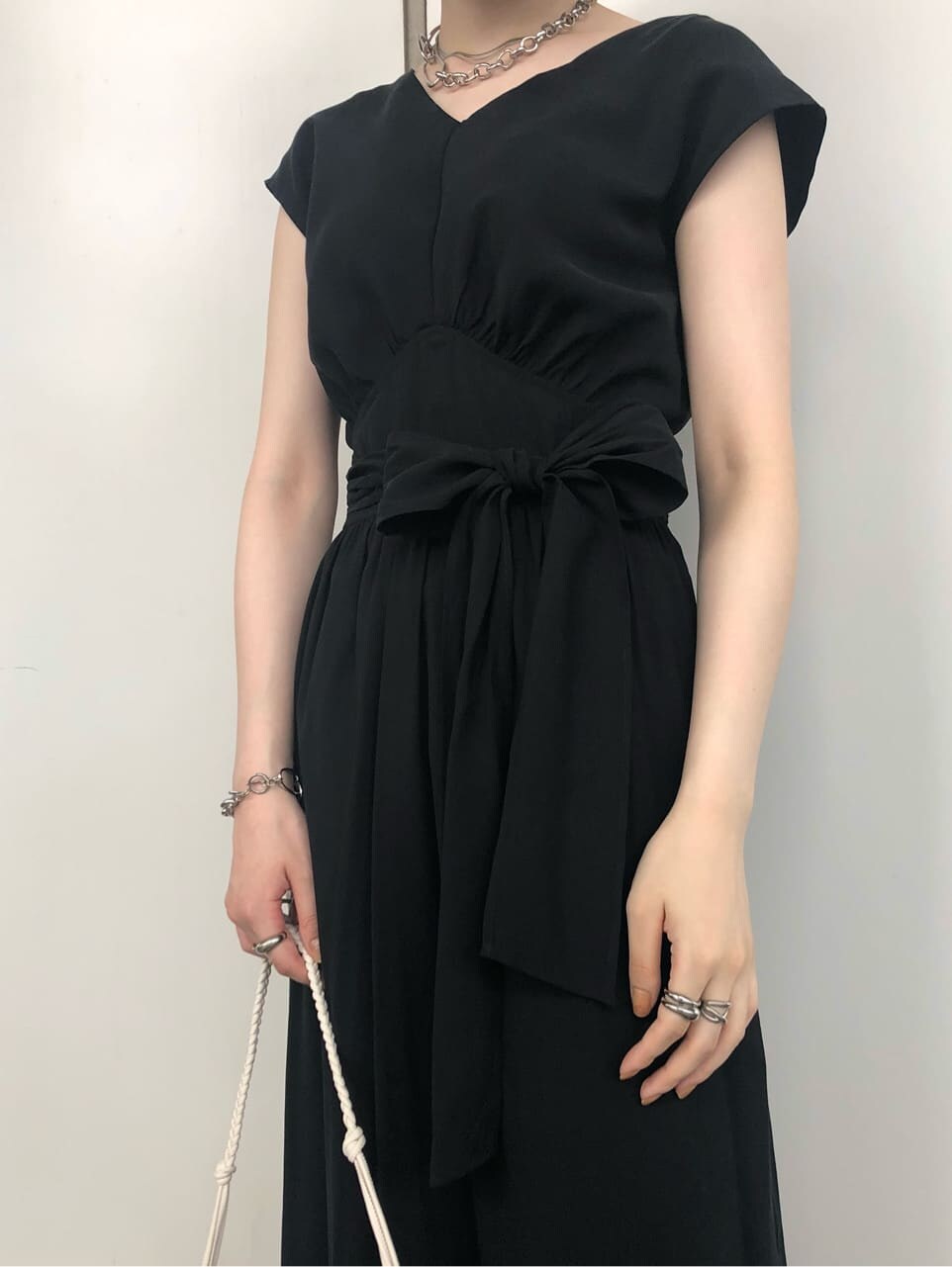 ホワイト系のショルダーバッグ、ブラック系のワンピース、ホワイト系のサンダルを着用したレディースの夏コーディネートの2枚目の写真