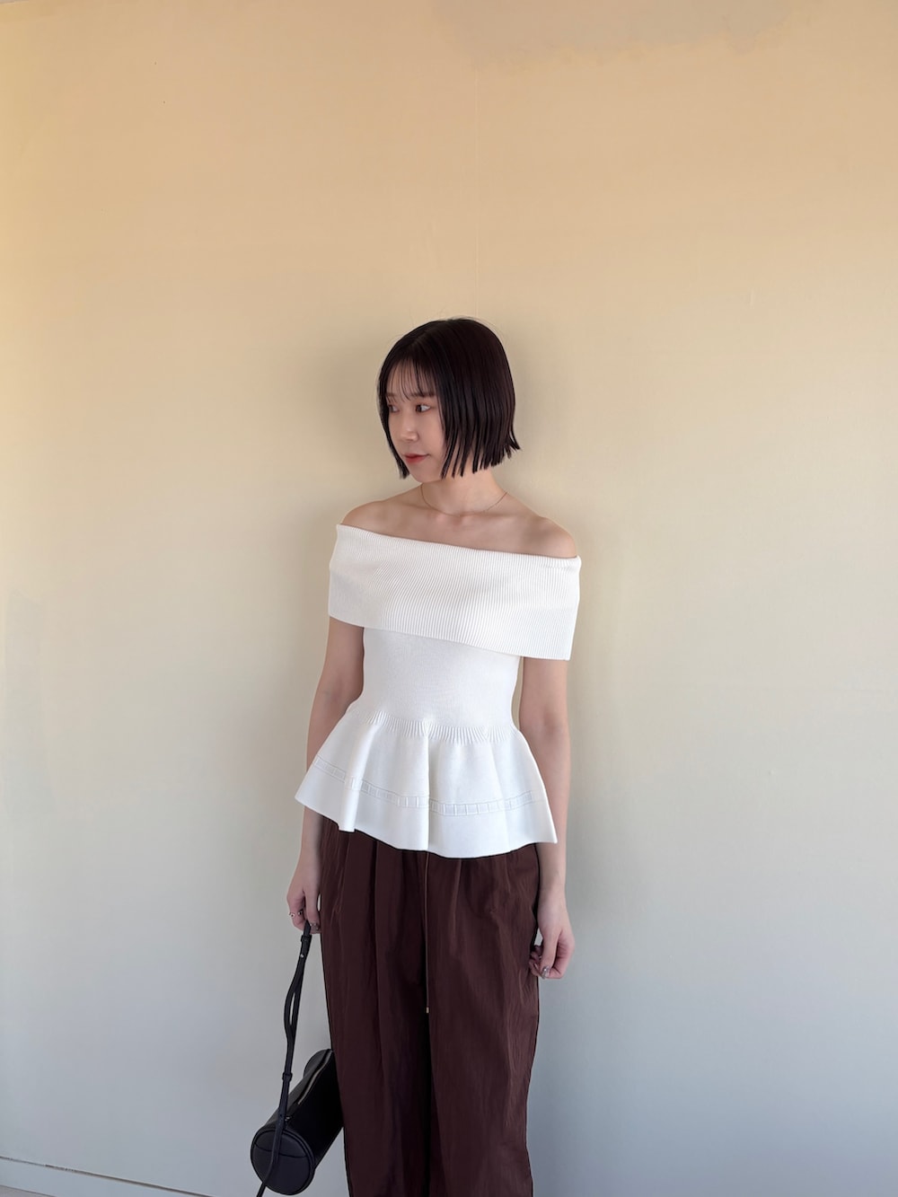 ブラウン系のその他パンツ、ブラック系のパンプス、ホワイト系のニット/セーターを着用したレディースの春コーディネートの5枚目の写真