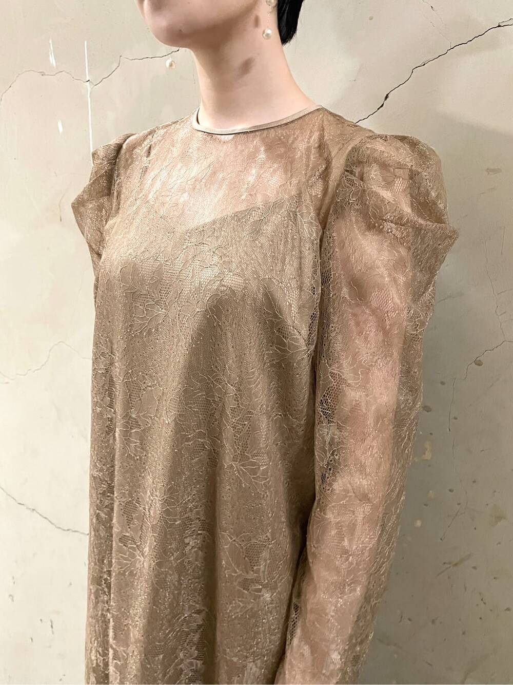 ゴールド系のパンプス、ベージュ系のドレス、ゴールド系のハンドバッグを着用したレディースの秋コーディネートの5枚目の写真