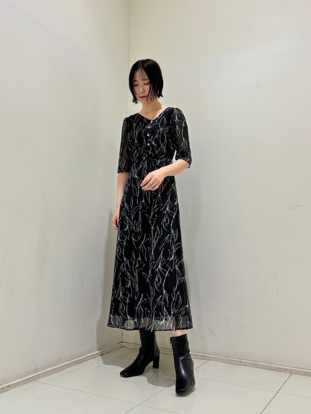ブラック系のワンピース、ブラック系のブーツを着用したレディースの秋コーディネートの2枚目の写真