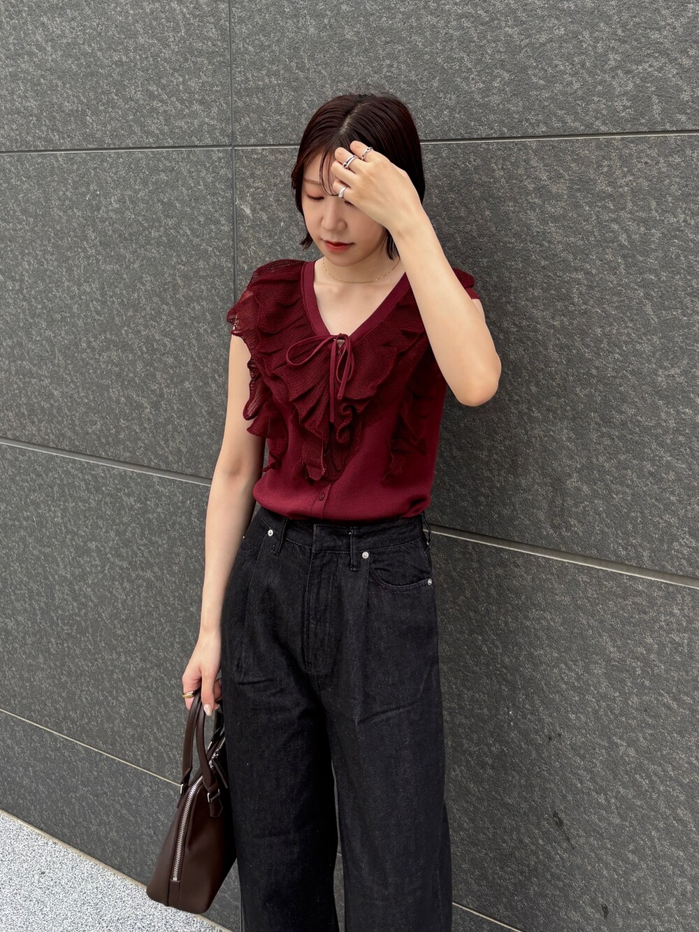 ブラウン系のボストンバッグ、ブラック系のデニムパンツ、ブラウン系のパンプスを着用したレディースの夏コーディネートの4枚目の写真