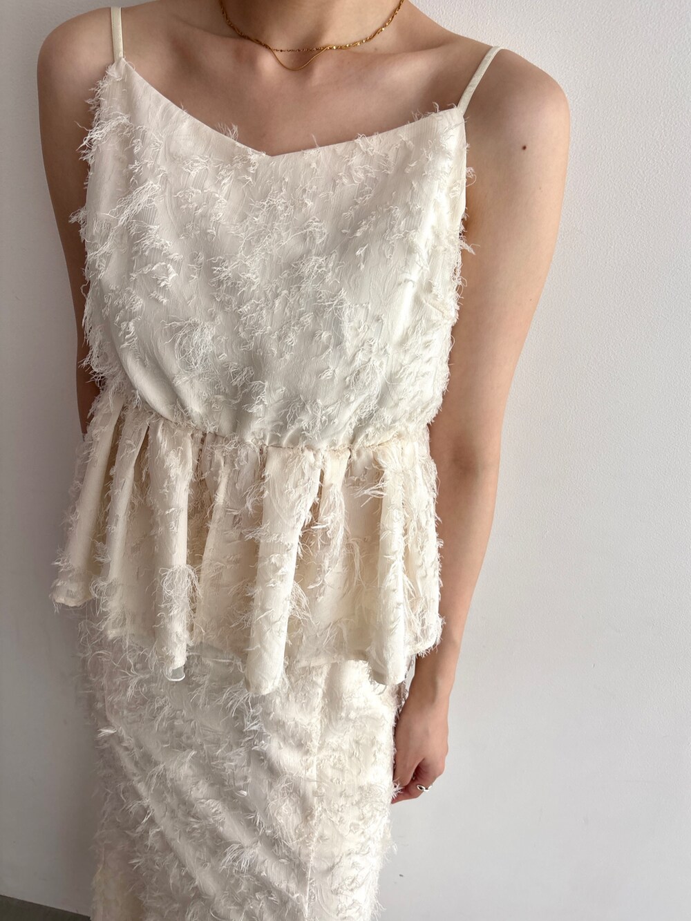 ホワイト系のキャミソール、ホワイト系のスカートを着用したレディースの夏コーディネートの5枚目の写真