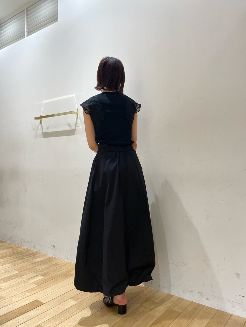 ベージュ系のハンドバッグ、ブラック系のサンダル、ブラック系のニット/セーターを着用したレディースの夏コーディネートの6枚目の写真