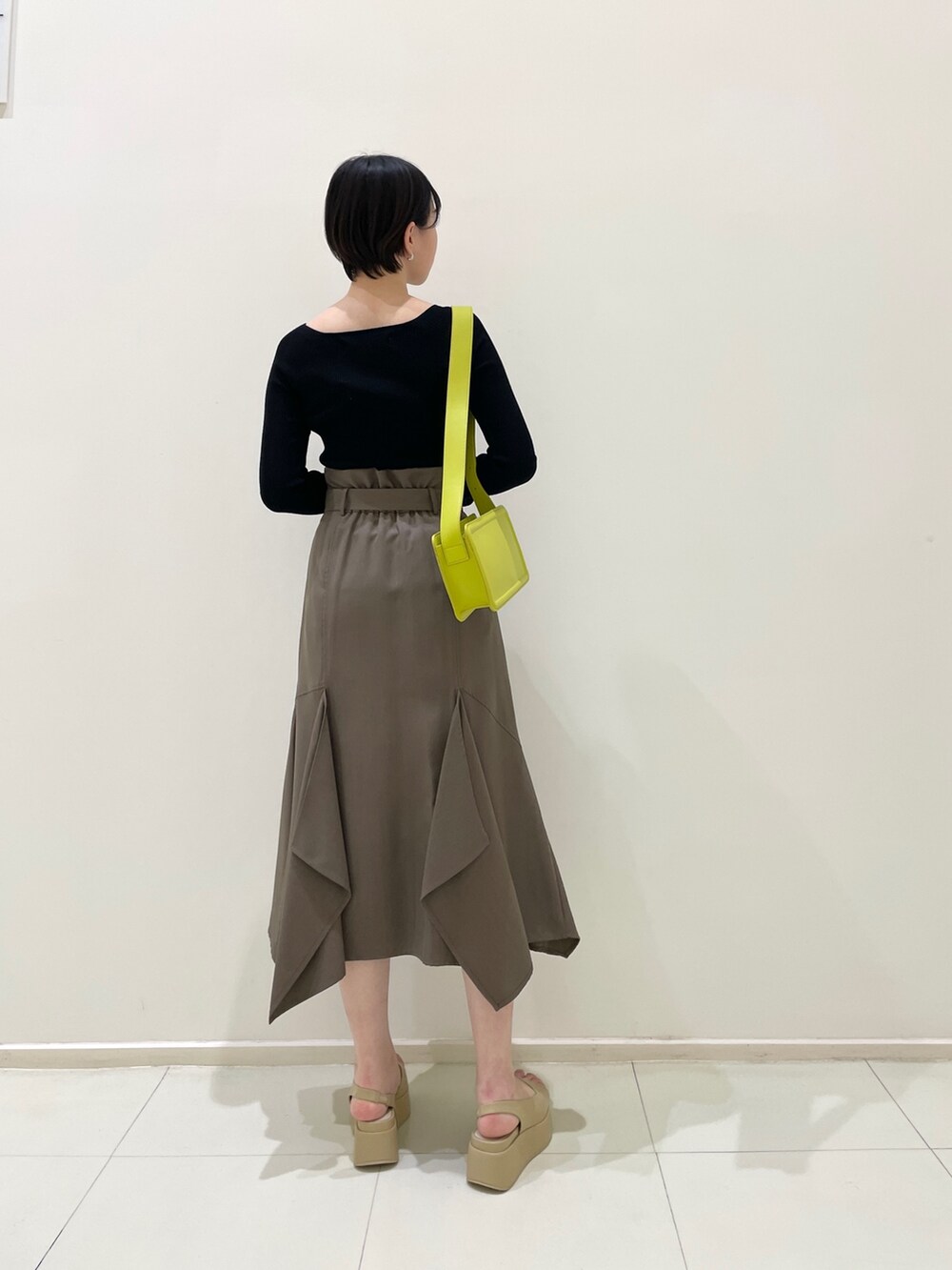 ブラウン系のスカート、ブラック系のニット/セーター、ベージュ系のサンダルを着用したレディースの春コーディネートの4枚目の写真