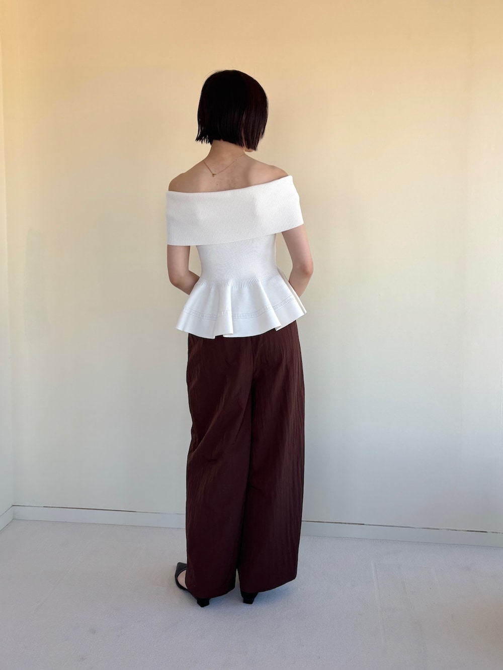 ブラウン系のその他パンツ、ブラック系のパンプス、ホワイト系のニット/セーターを着用したレディースの春コーディネートの4枚目の写真