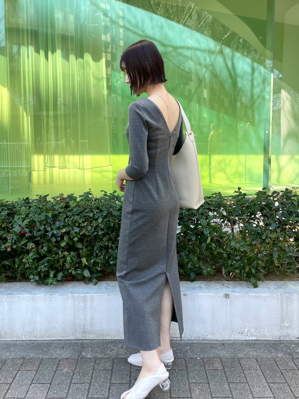 ホワイト系のパンプス、ホワイト系のショルダーバッグ、グレー系のワンピースを着用したレディースの冬コーディネートの9枚目の写真