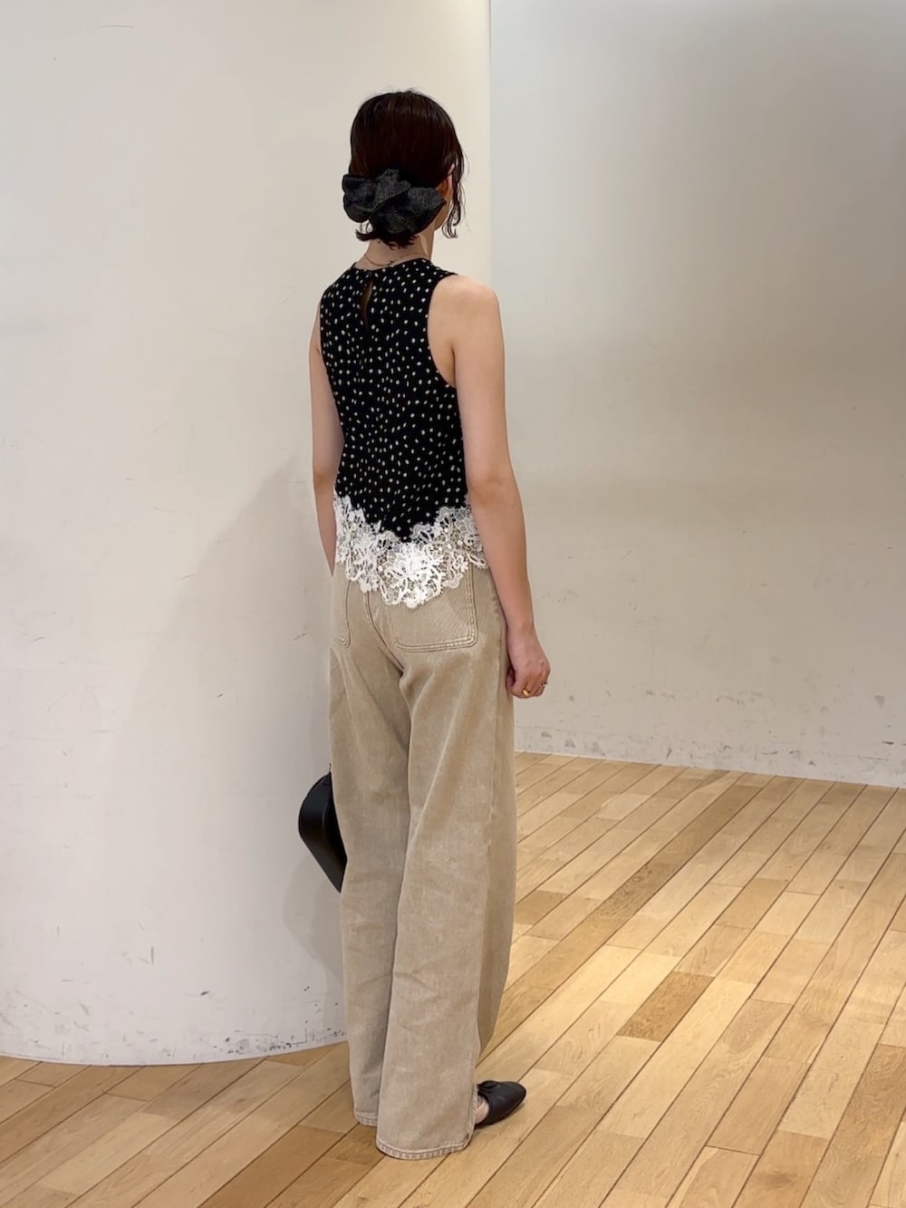 ベージュ系のデニムパンツ、ブラック系のシャツ/ブラウス、ブラック系のハンドバッグを着用したレディースの夏コーディネートの3枚目の写真