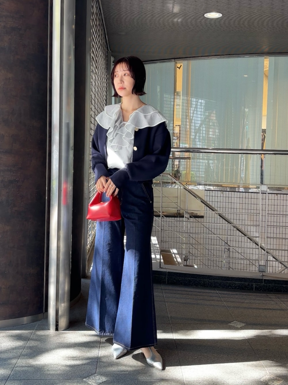 ホワイト系のシャツ/ブラウス、ブルー系のカーディガン/ボレロ、レッド系のハンドバッグを着用したレディースの冬コーディネートの2枚目の写真