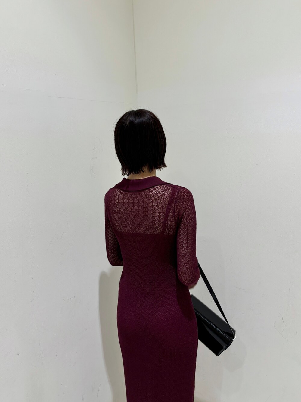 パープル系のワンピース、ブラック系のショルダーバッグ、シルバー系のブーツを着用したレディースの秋コーディネートの6枚目の写真