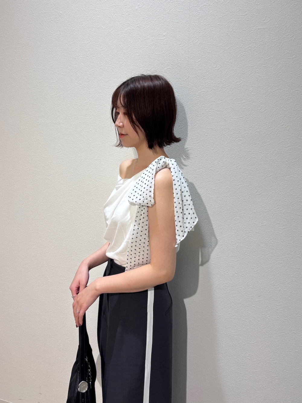 グレー系のその他パンツ、ホワイト系のサンダル、ブラック系のハンドバッグを着用したレディースの夏コーディネートの6枚目の写真
