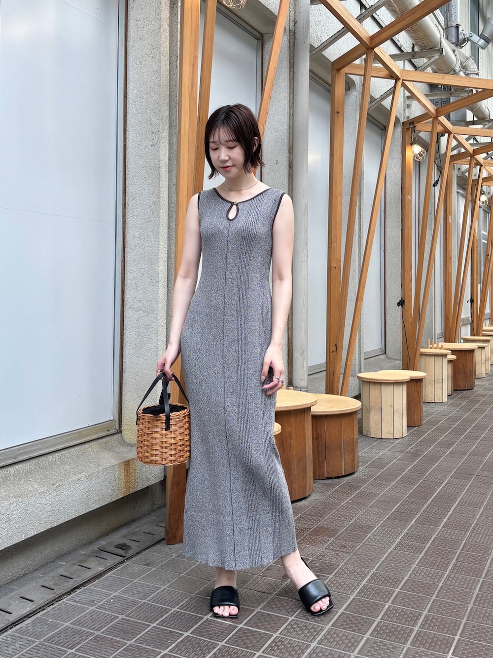 グレー系のワンピース、ブラウン系のハンドバッグを着用したレディースの夏コーディネートの2枚目の写真