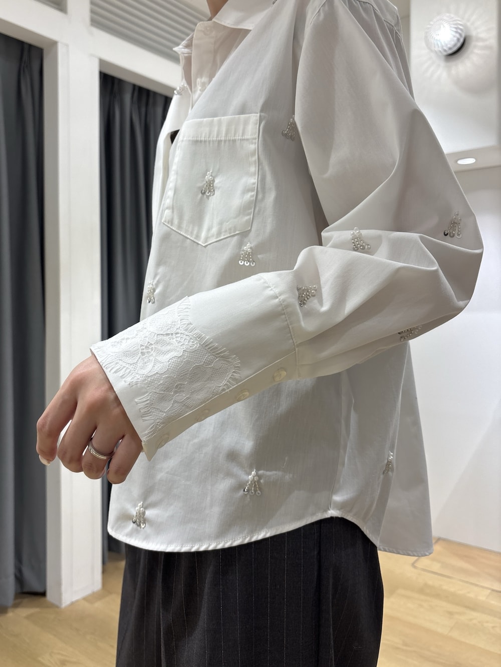グレー系のその他パンツ、ホワイト系のシャツ/ブラウス、ブラック系のハンドバッグを着用したレディースの秋コーディネートの7枚目の写真