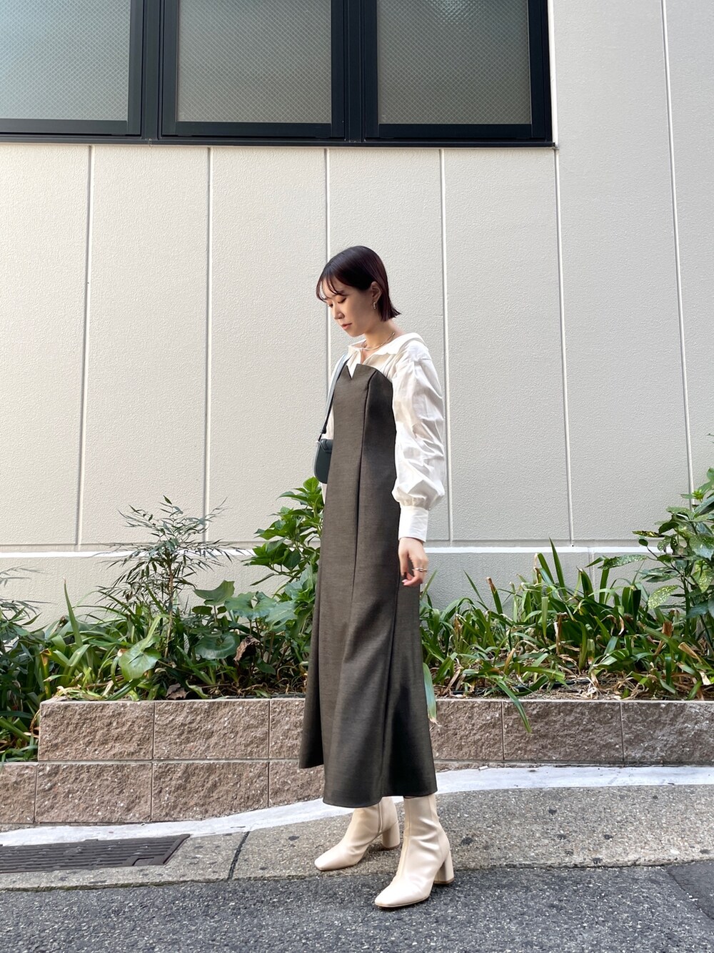 ブラウン系のワンピース、ブルー系のショルダーバッグ、ホワイト系のブーツを着用したレディースの秋コーディネートの2枚目の写真