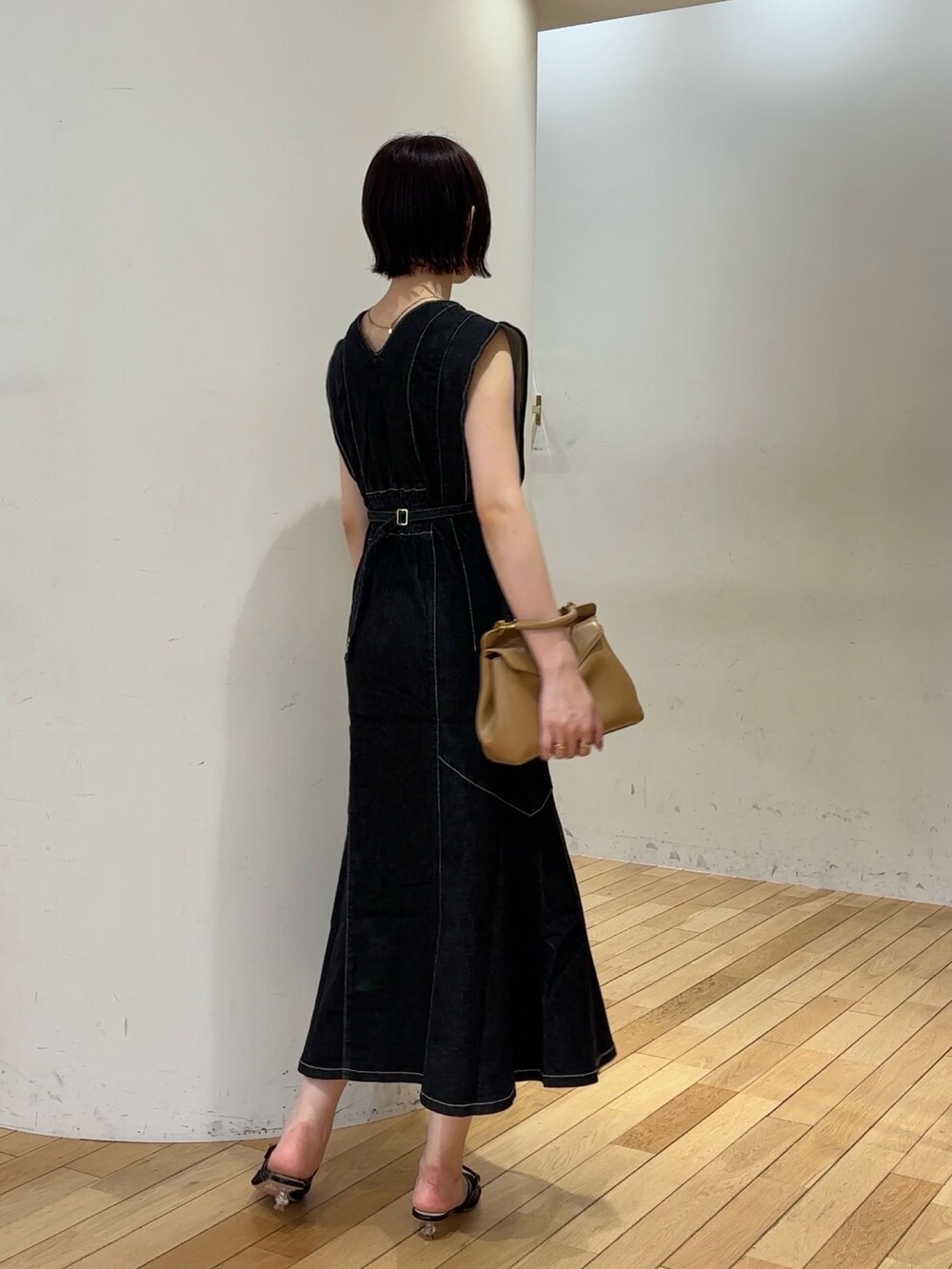 ブラック系のワンピース、ブラック系のサンダル、イエロー系のハンドバッグを着用したレディースの夏コーディネートの4枚目の写真